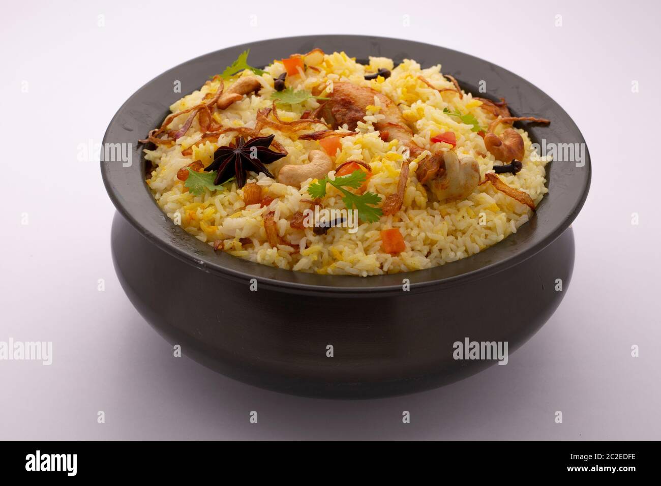 Biriyani  Huhn dum biriyani  kerala spezielle und leckere Speisen garniert mit Gewürzen, Cashewnuss und Korianderblatt in einem schwarzen Gefäße mit wh angeordnet Stockfoto