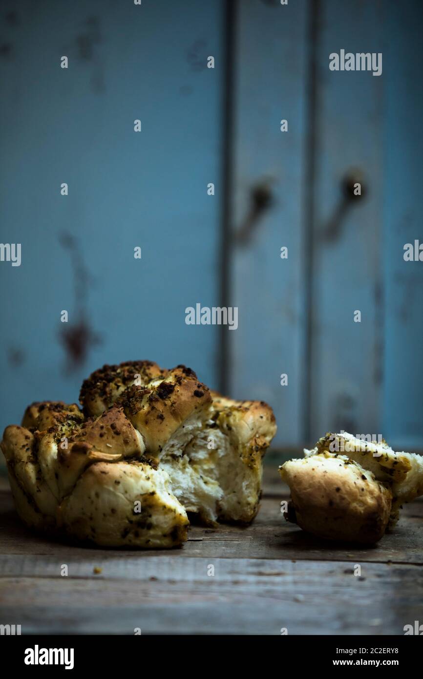 Gebackenes traditionelles Brot gefüllt mit Kräutern und Käse auf einem Holztisch in der Küche Stockfoto