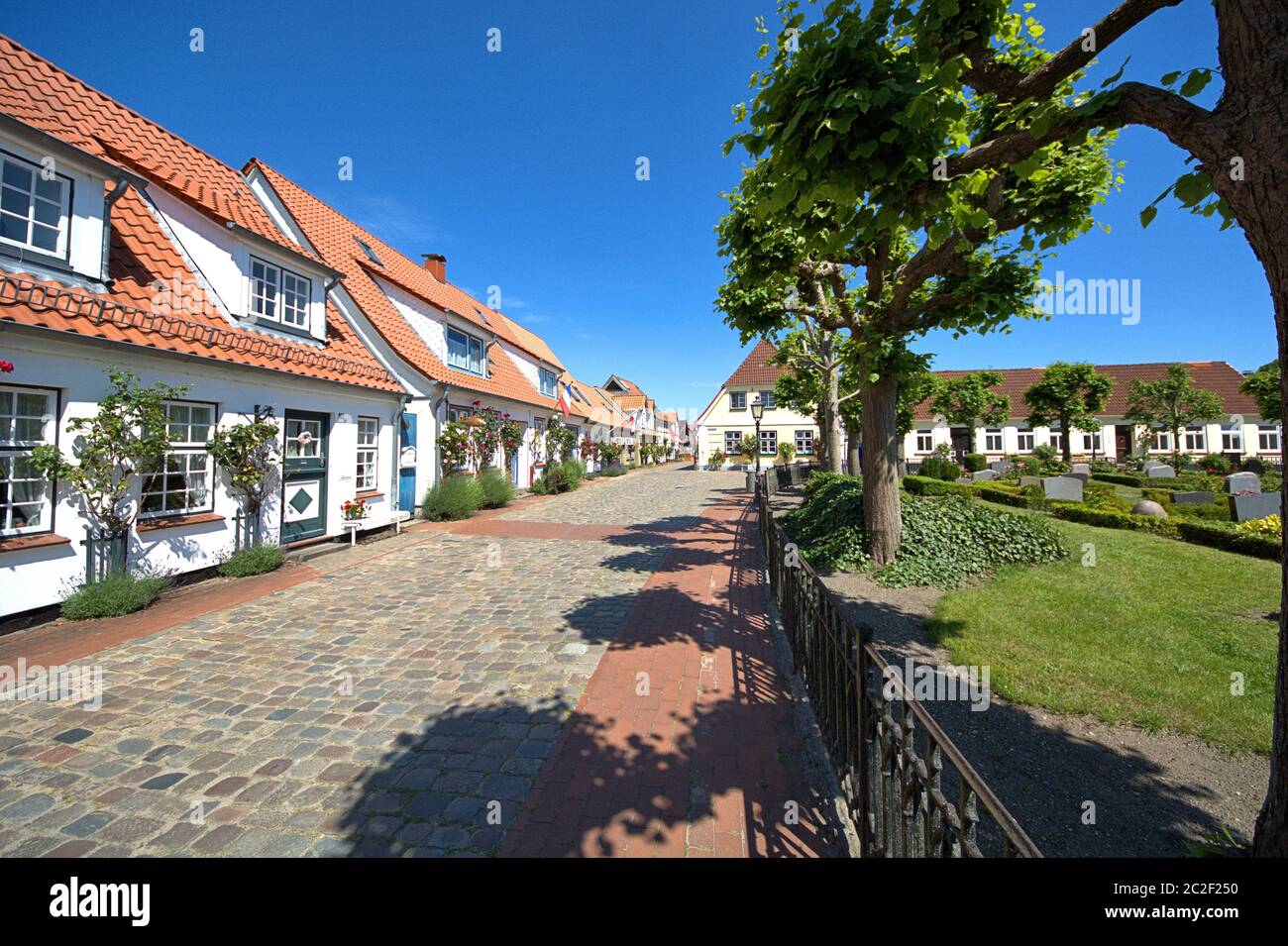 16.06.2020, Schleswig, die Fischersiedlung Holm in der Altstadt von Schleswig mit den charakteristischen Häusern, die um den zentralen Friedhof angeordnet sind und die Friedhofskapelle des Holmer beliebt. Foto an einem schönen Frühlingstag. Der Name der Siedlung basiert auf dem norddeutschen oder dänischen Wort Holm. Es bedeutet kleine Insel. Weltweit eingesetzt Stockfoto