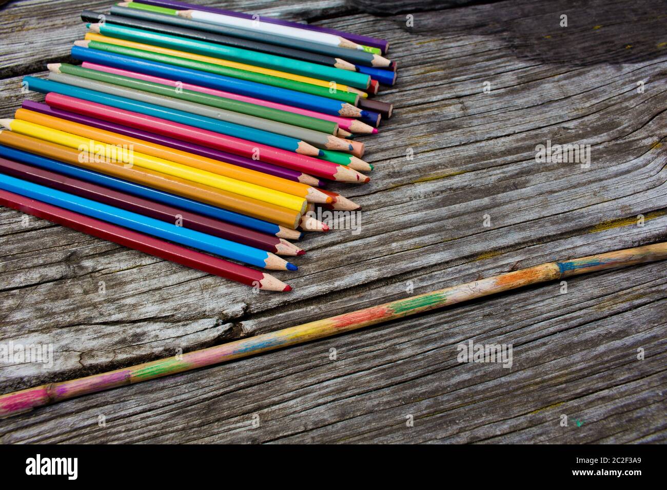 Buntstifte auf Holzhintergrund und bemalter Bambusstock Stockfoto