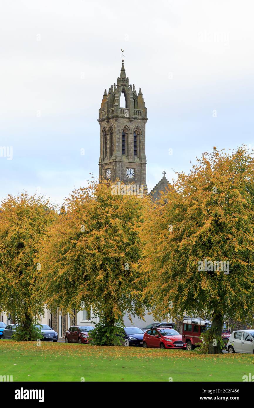 PEEBLES, SCHOTTLAND - 20. OKTOBER 2019: Peebles Old Parish Kirchturm und Uhr mit Bäumen in Herbstfarben im Vordergrund Stockfoto