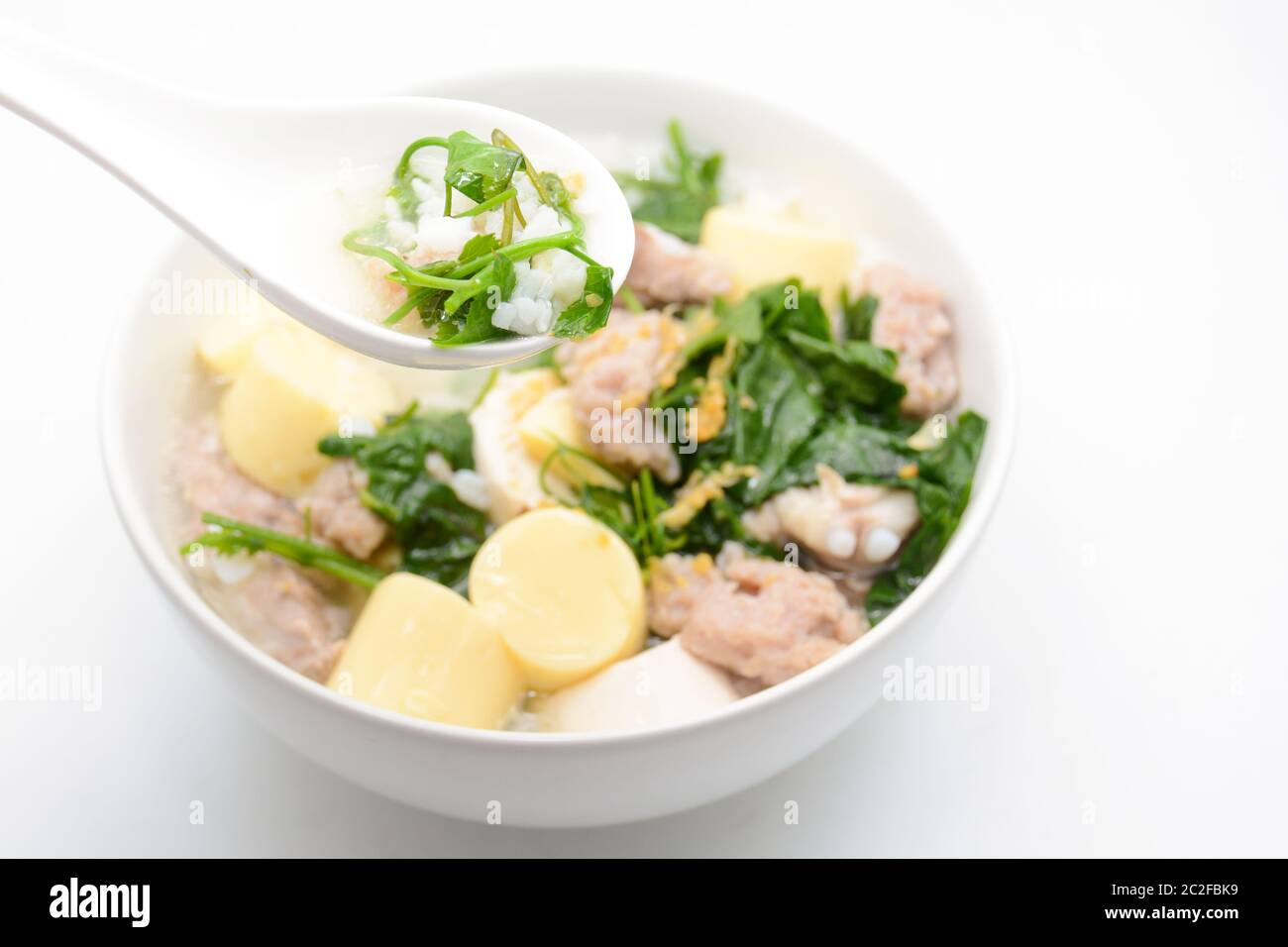 Gekochter Reis mit Schweinefleisch, Efeu-Kürbisblättern und weichem Tofu Stockfoto
