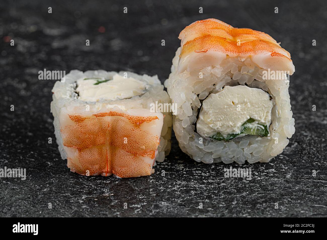 japan Sushi-Rollen mit Lachs, Garnelen und geräuchertem Aal mit Frischkäse auf schwarzer Platte Stockfoto