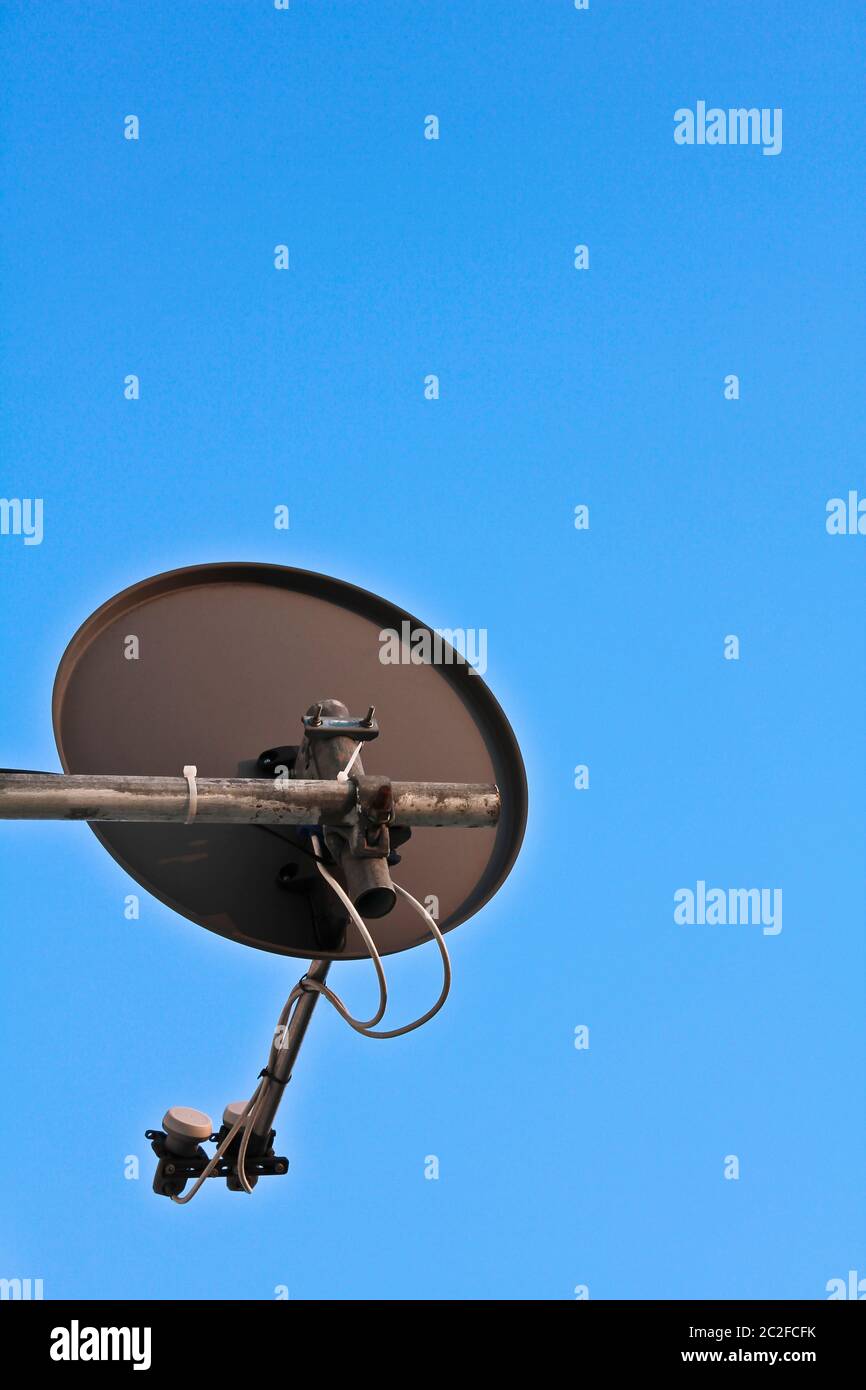 Sat-Schüssel mit einem blauen Himmel im Hintergrund. Stockfoto