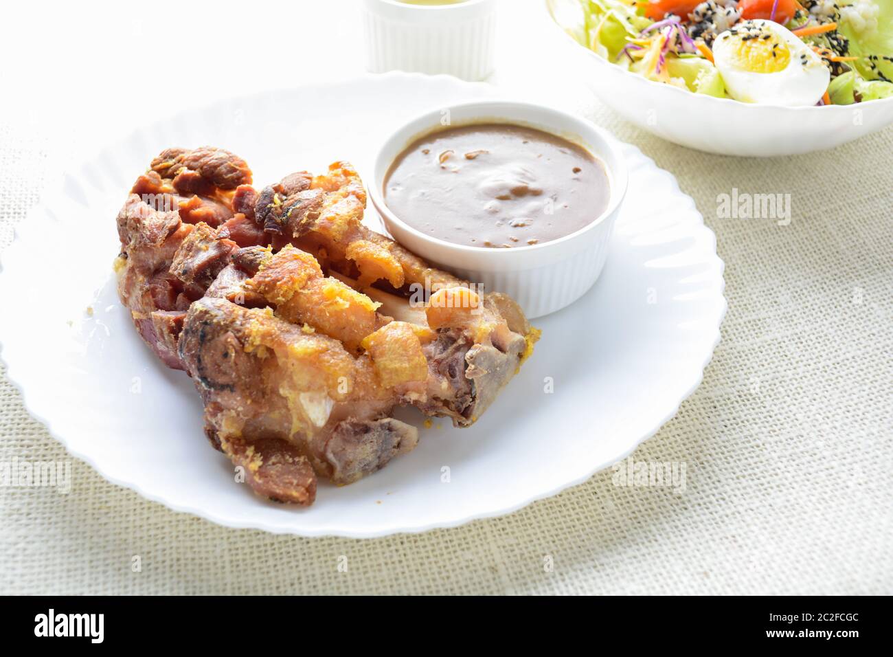 Frittierte Schweinshaxe mit Pilzsoße, frischem Gemüse und Salatsahne Stockfoto