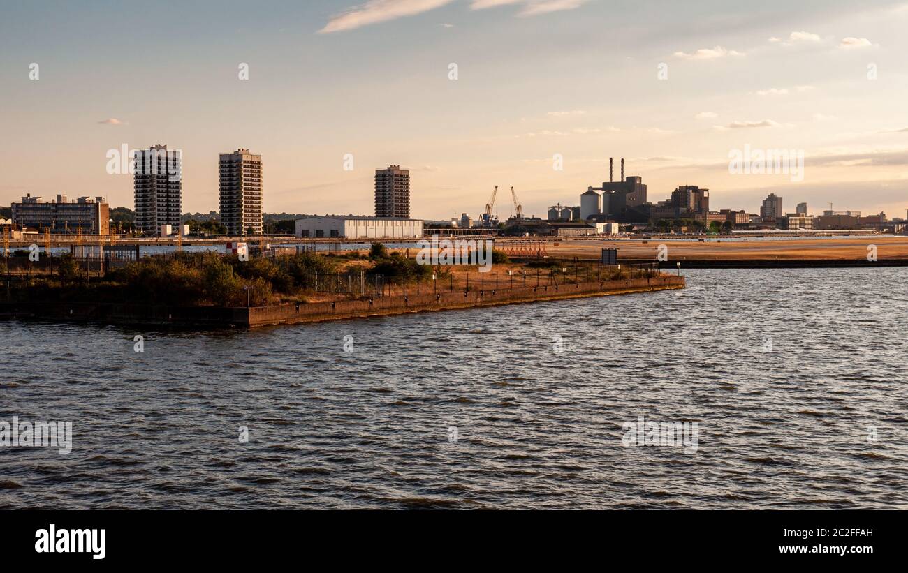 London, England, Großbritannien - 31. Juli 2010: Der Sonnenuntergang wirft einen Schein über dem Royal Albert Dock und dem London City Airport, mit dem Hochhaus-turm des council Stockfoto