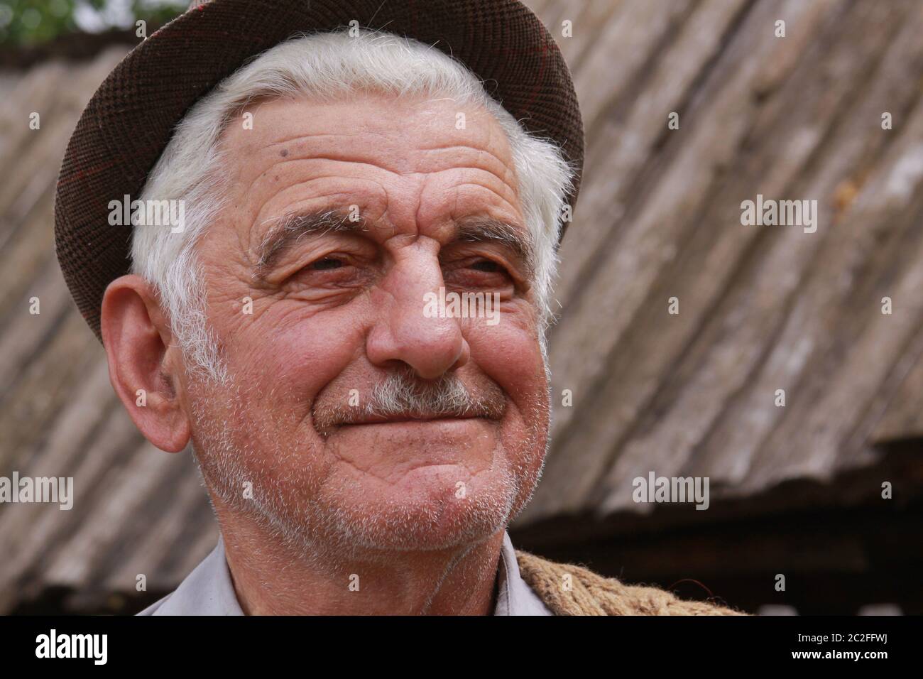 Lächelnder kaukasischer alter Mann mit Hut und weißem Haar, in Osteuropa Stockfoto