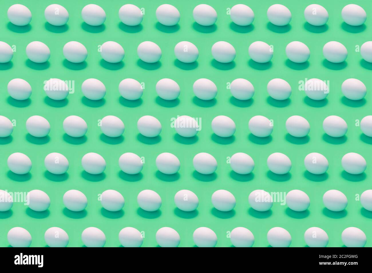 Viele weiße Eier auf einfarbigem Hintergrund Stockfoto