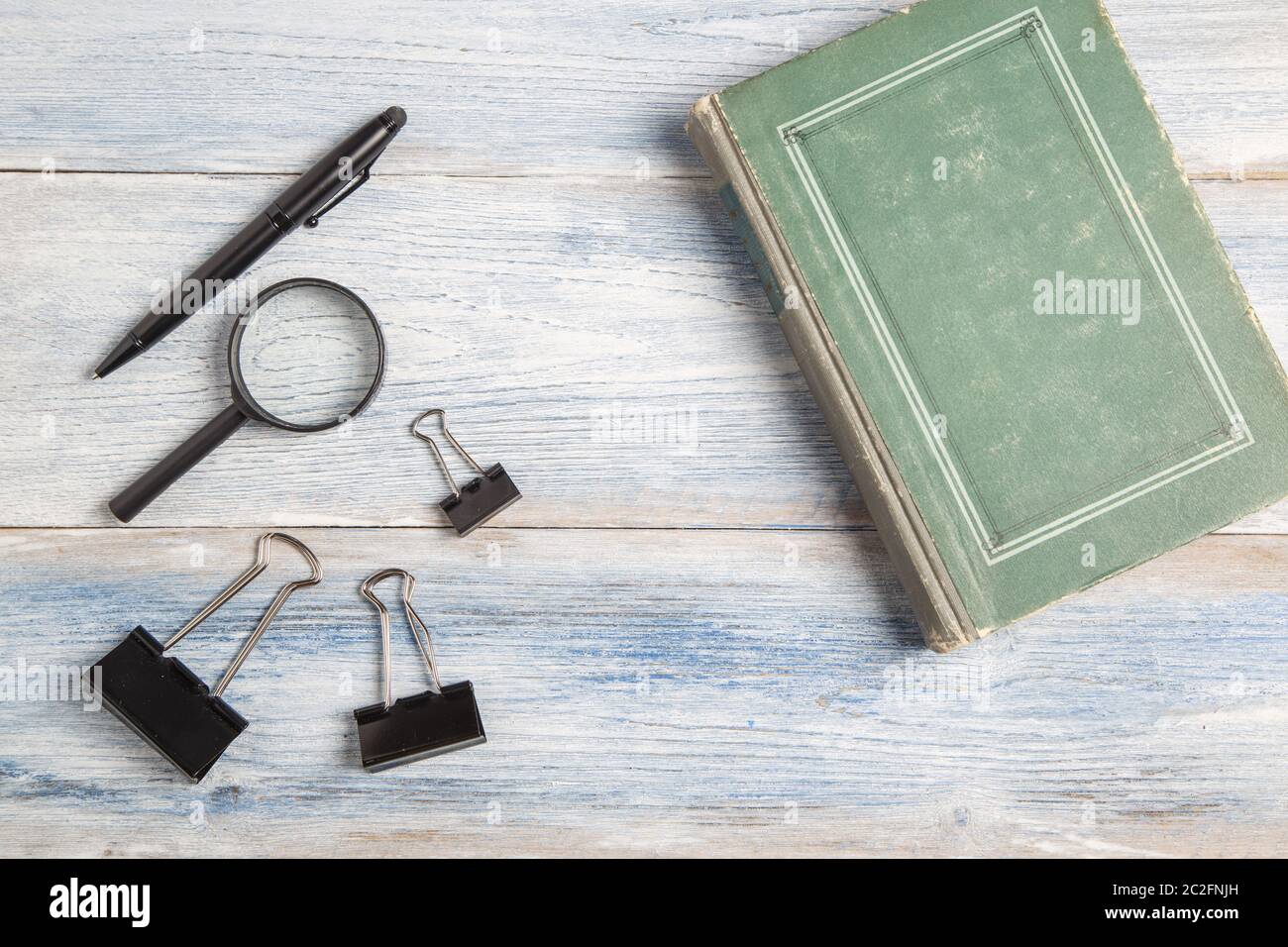 Schreibwaren, Lupe, Pen und Buch auf Hellblau alten hölzernen Hintergrund. top anzeigen. Flach Stockfoto