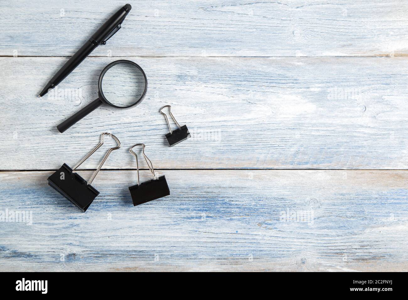 Schreibwaren, Lupe, Pen auf Hellblau alten hölzernen Hintergrund. top anzeigen. Flach Stockfoto