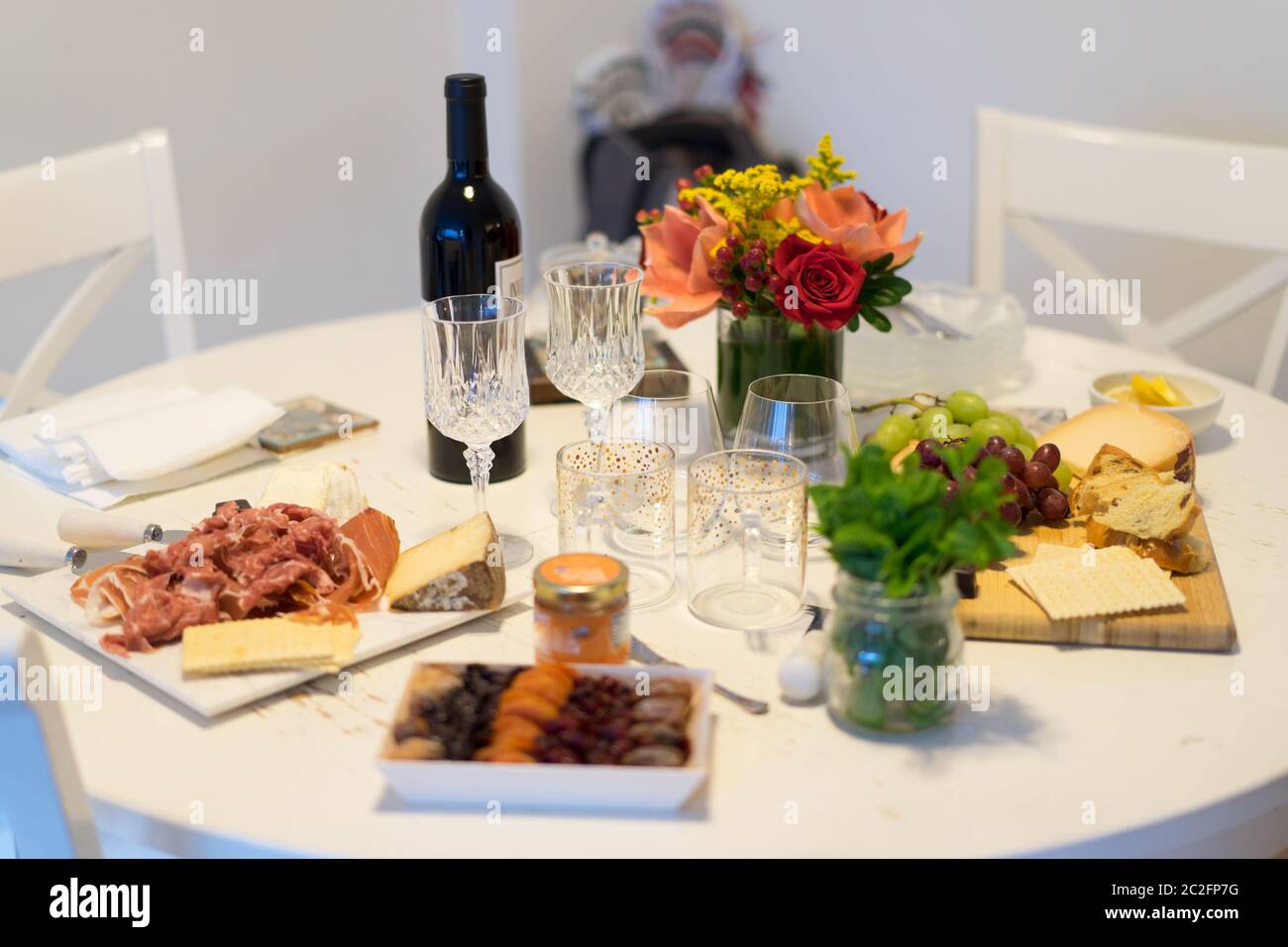 Dekoration auf dem Tisch. Blumenarrangement mit Käse Vorspeise, Obst und Wein. Stockfoto