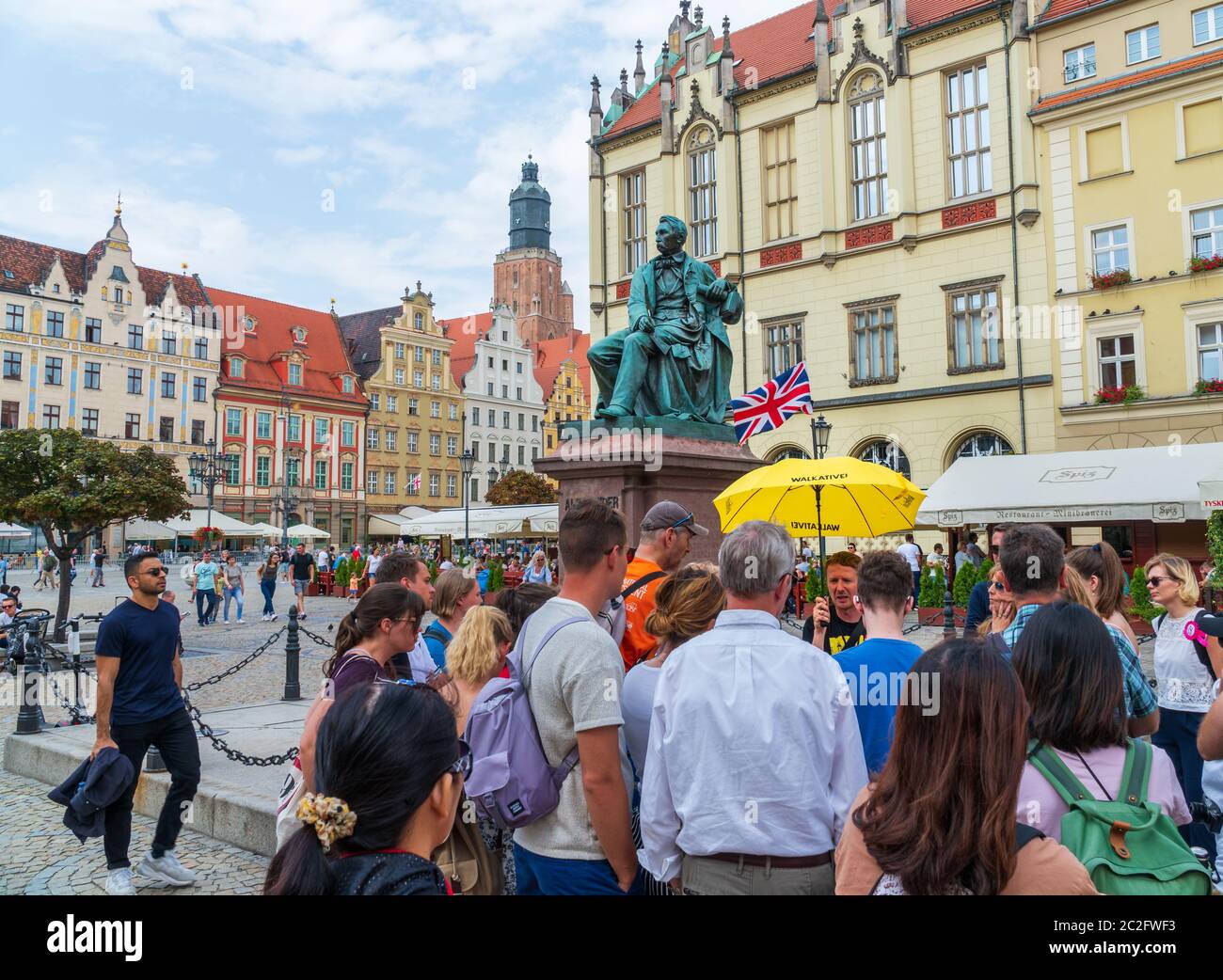 Breslau, Polen - 16. August 2019: Touristen auf einer kostenlosen Führung, die einem Reiseleiter vor dem Aleksander Fredro Denkmal lauschen. Stockfoto