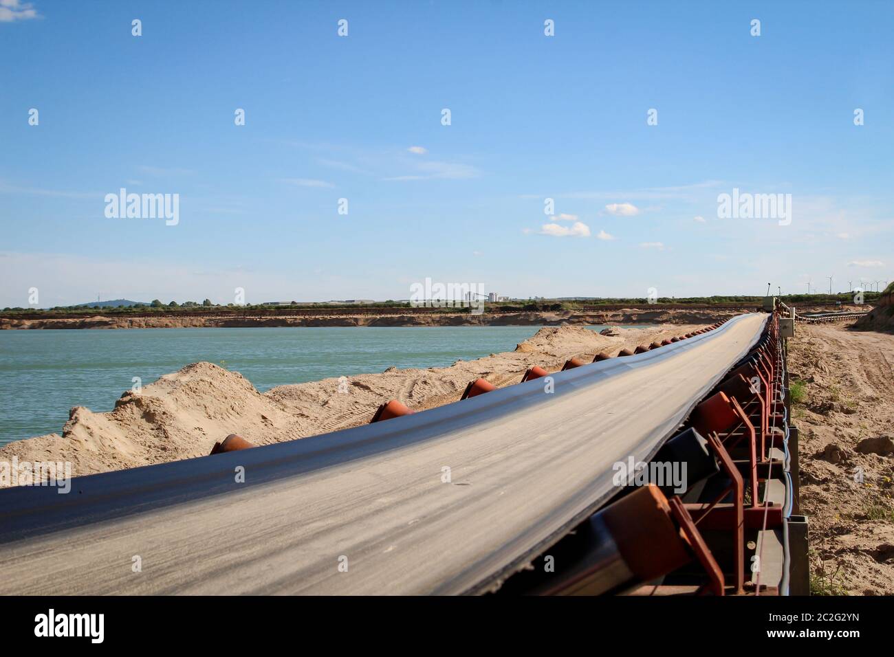 Eine Kette von Transportbändern in einer Schottergrube zum Transport von Kies und Sand über weite Strecken. Stockfoto