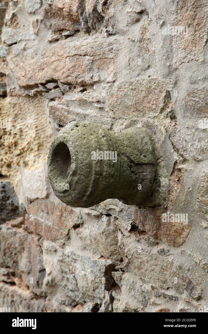 Ein Kanonenfass wurde in eine alte Burgmauer eingemauert Stockfoto