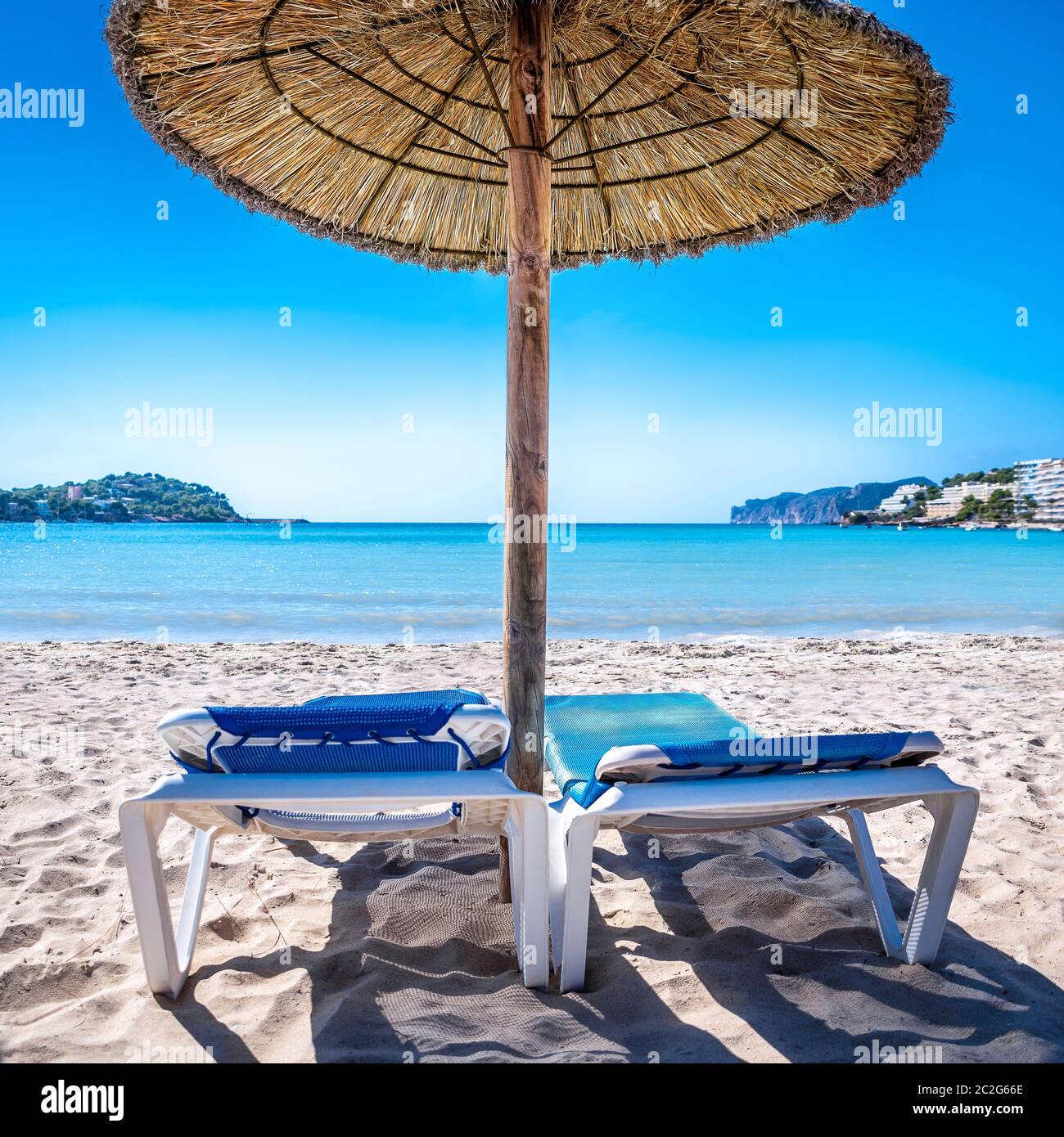 Liegen mit Sonnenschirm vor blauem Himmel Stockfoto