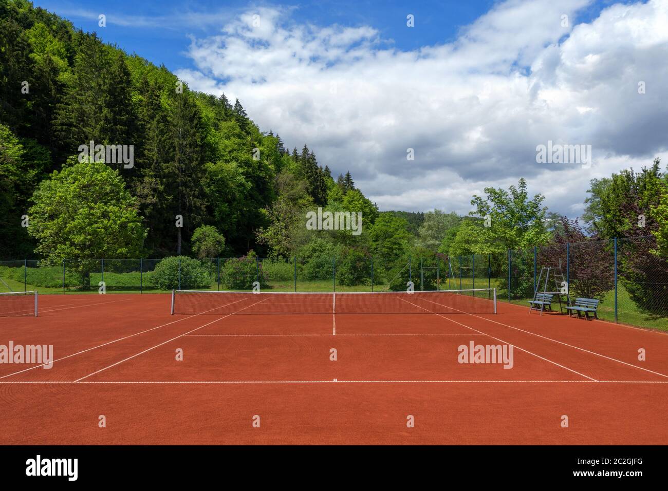 Nach der Frühjahrsüberholung wurde der Tennisplatz mit rotem Sand sauber gezogen Stockfoto