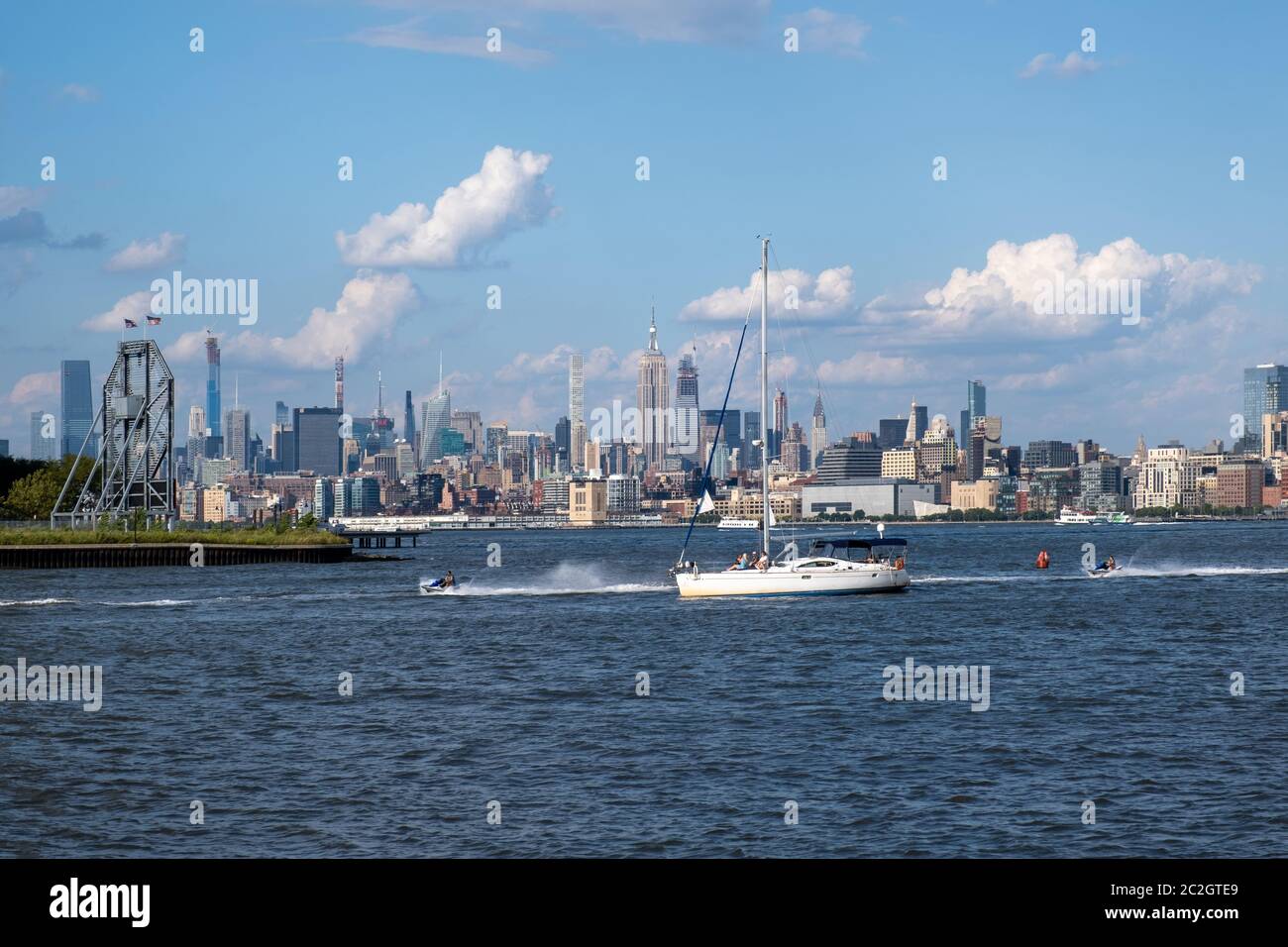 Skyline von Lower Manhattan mit Blick auf Boot und Fähre auf den Hudson River vom Liberty State Park im Spätsommer Stockfoto