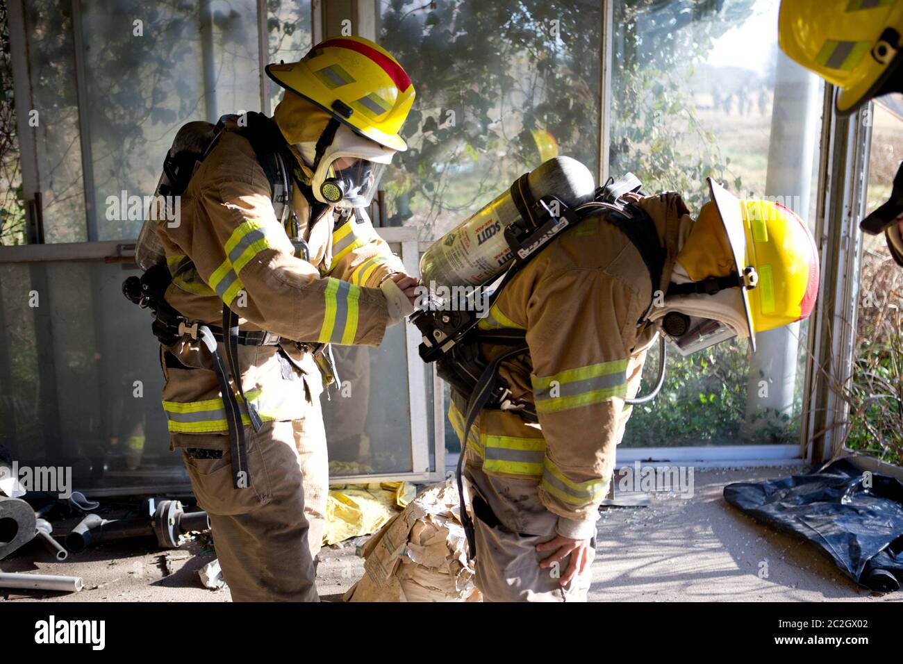 Austin Texas, USA, Februar 4 2014: Schüler der LBJ High School Fire Training Academy tragen Atemschutzgeräte, Airtanks und Schutzhelme und bereiten sich auf eine Trainingsübung in einem mit Rauch gefüllten Gebäude vor. Studierende, die das zweijährige Programm absolvieren, sind für die EMT-Zertifizierung als Notarzt qualifiziert und verfügen über fortgeschrittene Fähigkeiten zur Brandbekämpfung. ©Bob Daemmrich Stockfoto