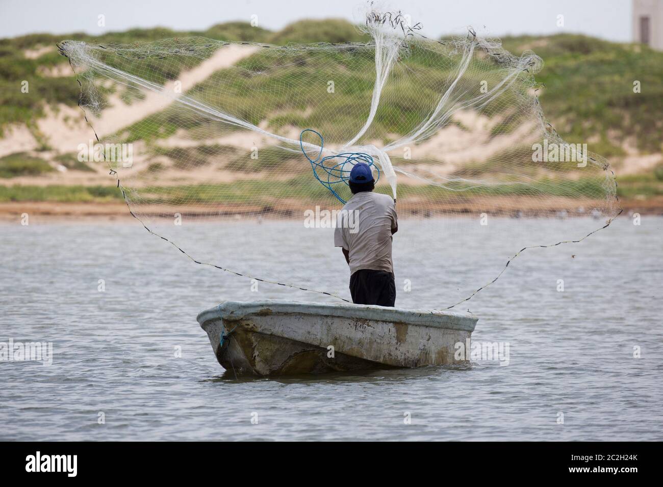 Boca Chica Beach Texas USA, 23. September 2014: Ein mexikanischer Fischer wirft sein Netz in Richtung der US-amerikanischen Seite des Rio Grande River am Boca Chica Beach, wo der Fluss, der Mexiko von Texas trennt, in den Golf von Mexiko fließt. Die US-Grenze ist ungesichert in diesem Gebiet, mit nur gelegentlichen Patrouillen durch die USA Grenzpolizei. ©Bob Daemmrich Stockfoto