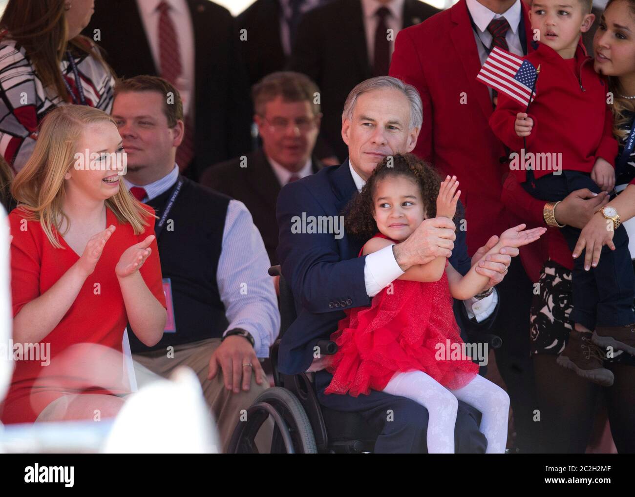 Austin Texas, USA, Januar 20 2015: Der neue texanische Gouverneur Greg Abbott feiert seine Amtseinführung mit seiner Familie, während er kurz nach seiner Vereidigung die Eröffnungsfeier auf der Congress Avenue sieht. Seine Nichte Chrisma Boone liegt auf seinem Schoß und seine Tochter Audrey sitzt links. ©Bob Daemmrich Stockfoto