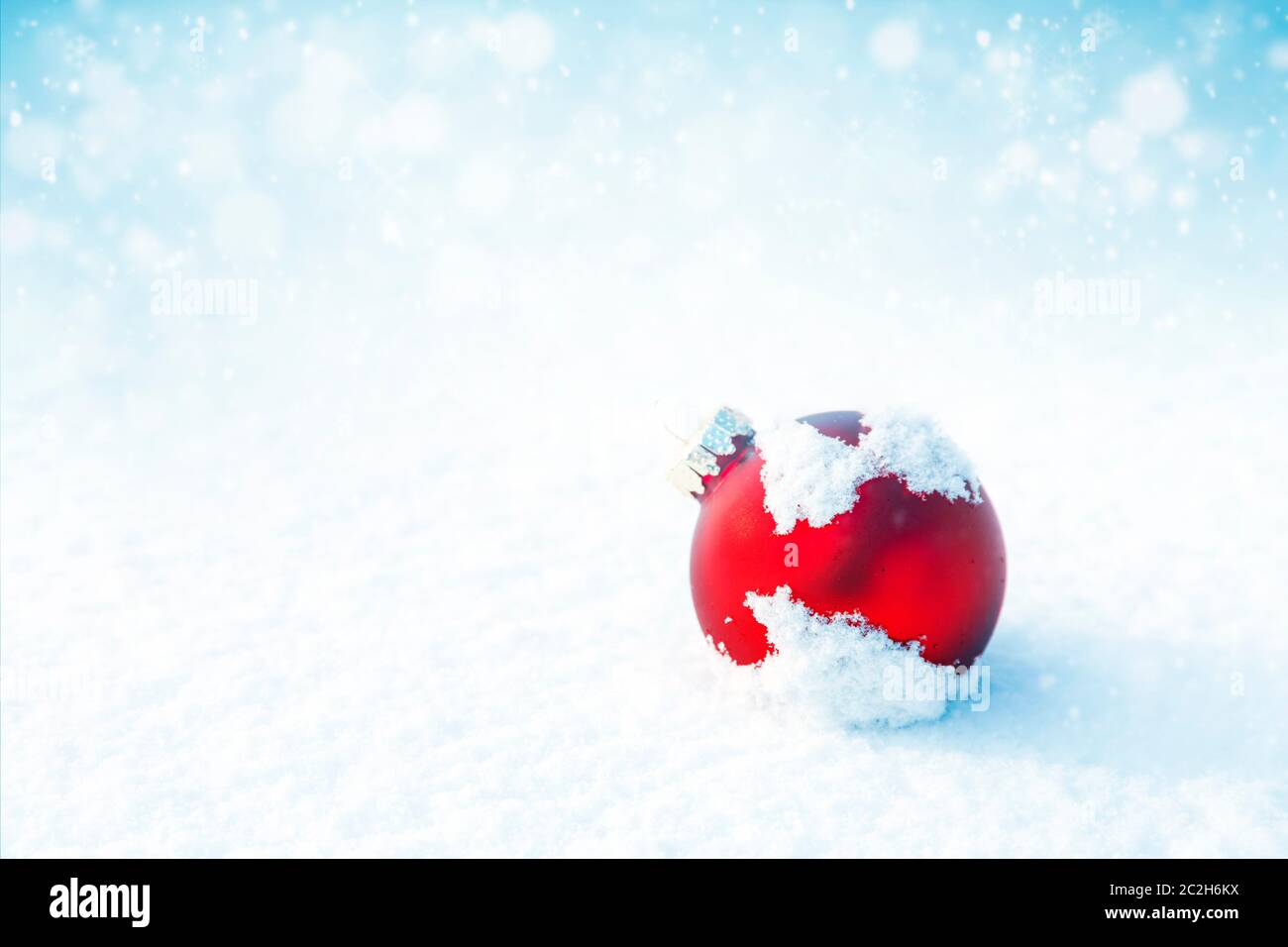 Weihnachten rote Kugel auf weißem Schnee Hintergrund Stockfoto
