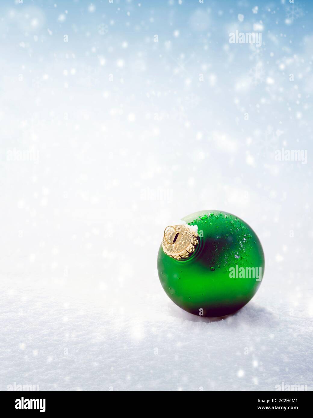 Weihnachtliche grüne Kugel auf weißem Schnee Hintergrund Stockfoto