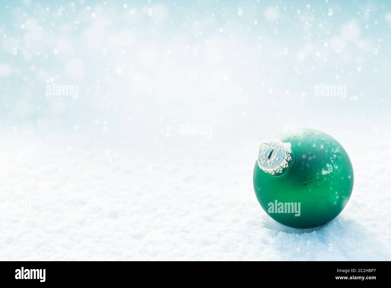 Weihnachtliche grüne Kugel auf weißem Schnee Hintergrund Stockfoto