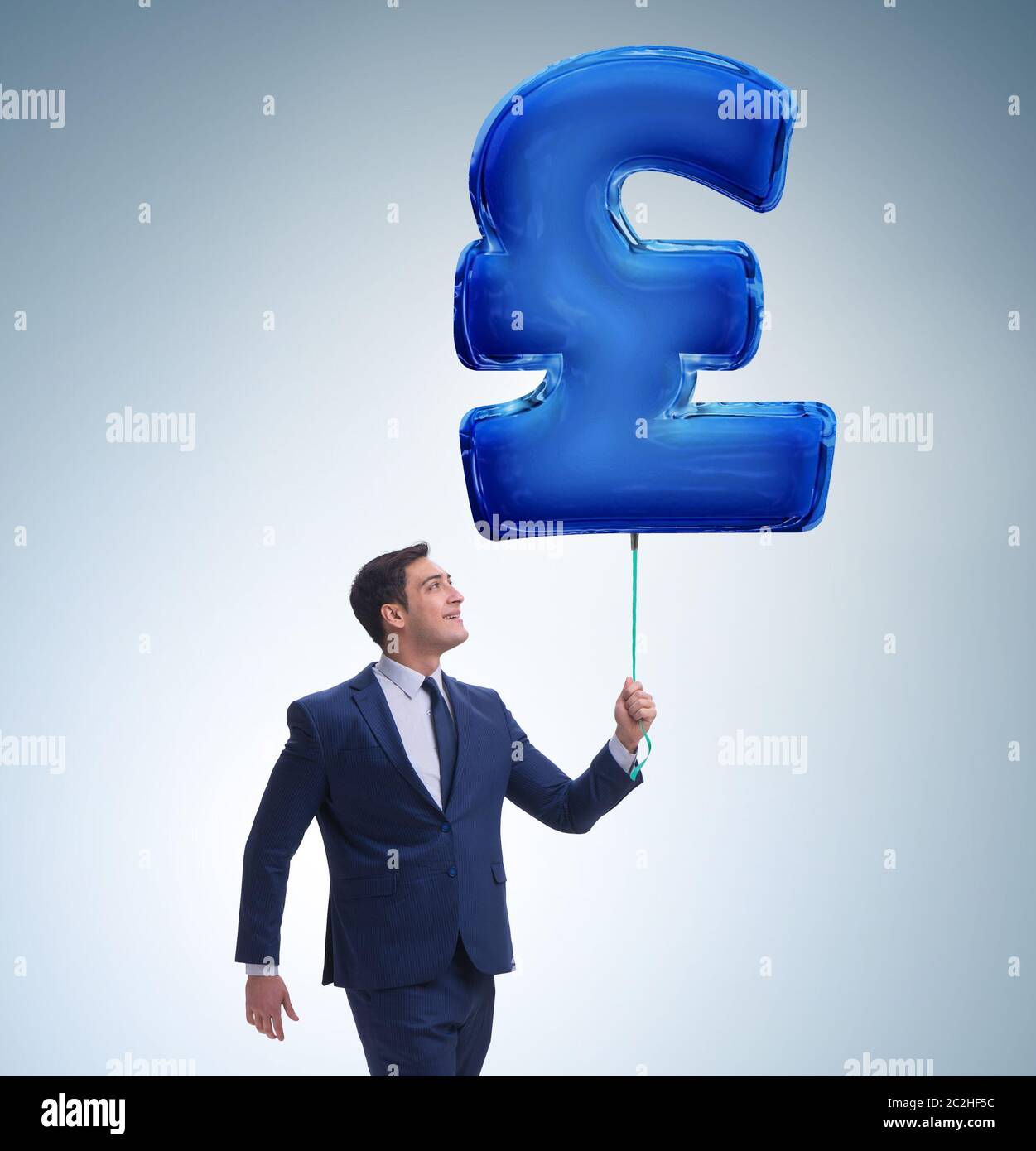 Unternehmer gehen mit aufblasbaren british pound Sign Stockfoto