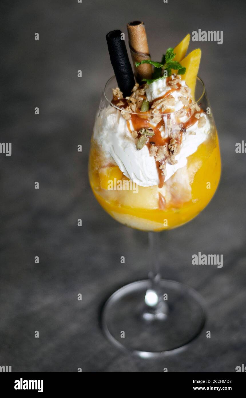 Bio Mango und Passionsfrucht tropische Eisbecher in Wein Glas Stockfoto