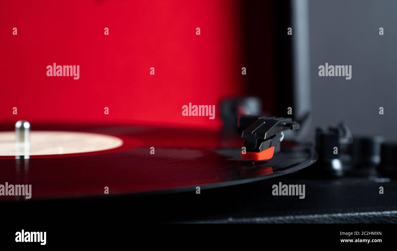 Vinyl Nadel Stift auf rotierenden schwarzen Vinyl-Disk mit Kopierraum. Plattenspieler Vinyl auf rotem Hintergrund Stockfoto