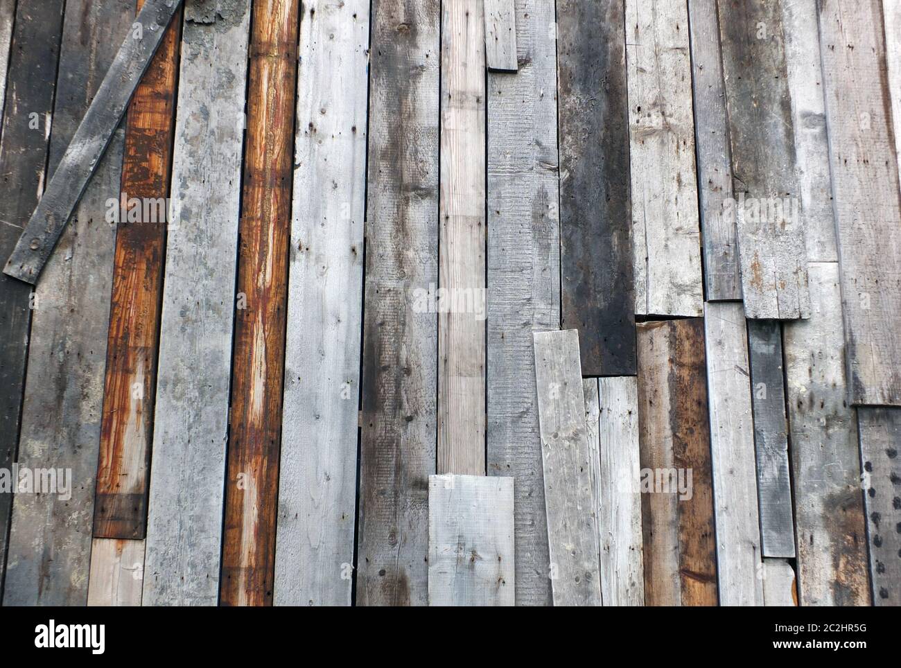 Raue strukturierte Holzoberfläche aus gebeizten, nicht aufeinander abgestimmten recycelten alten Planken Stockfoto