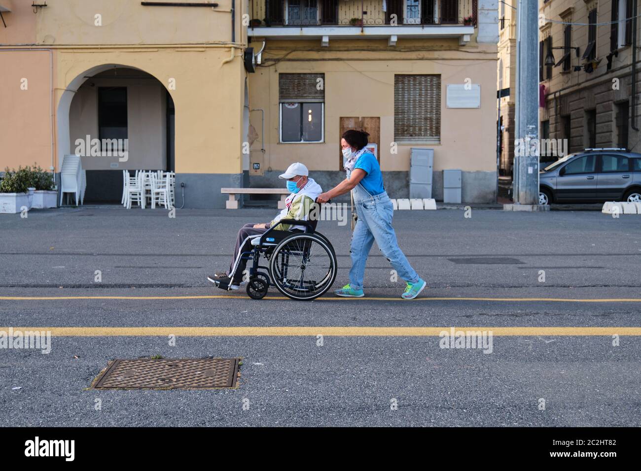 Pflege von alten Mann Rollstuhl mit Schutz medizinische Maske covid-19 Quarantäne. Ältere Männer Hilfe durch weibliche Eltern Pandemie Coronavirus. Stockfoto