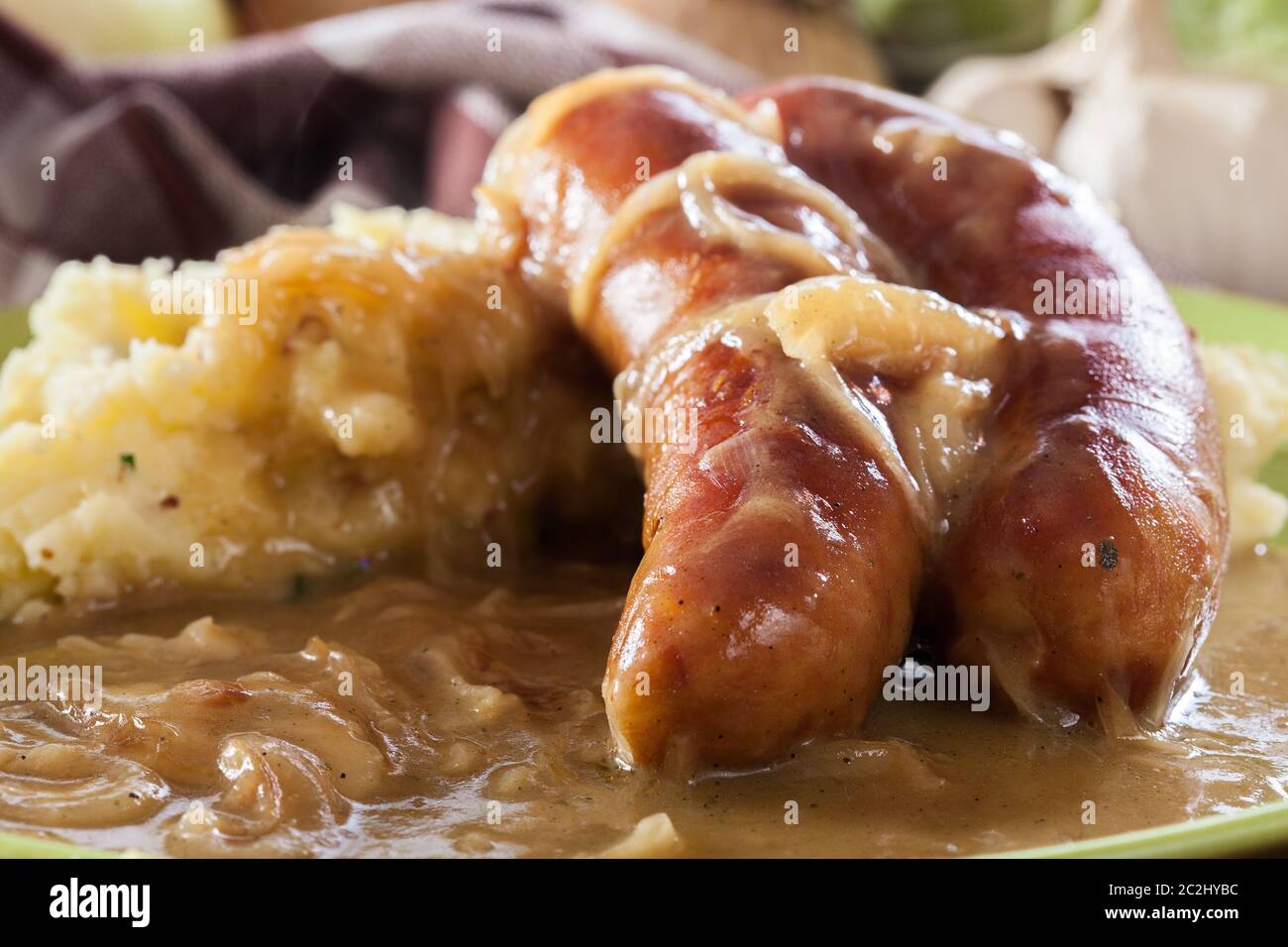 Würstchen mit Kartoffelbrei. Gebackene Wurst im Onion gravy mit Kartoffelpüree serviert. Stockfoto