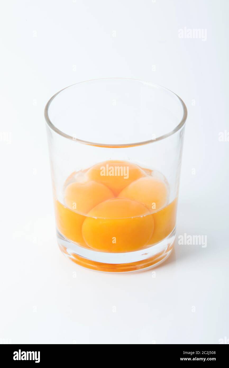 Vier Eigelb in einem Glas Stockfoto