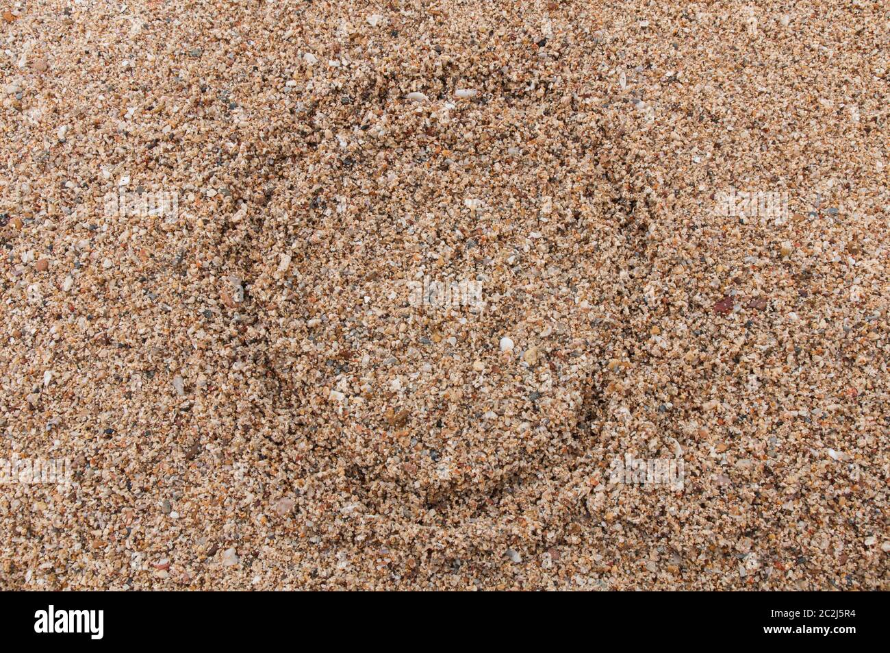 O Zeichen des Alphabets schreiben auf dem Sand Stockfoto