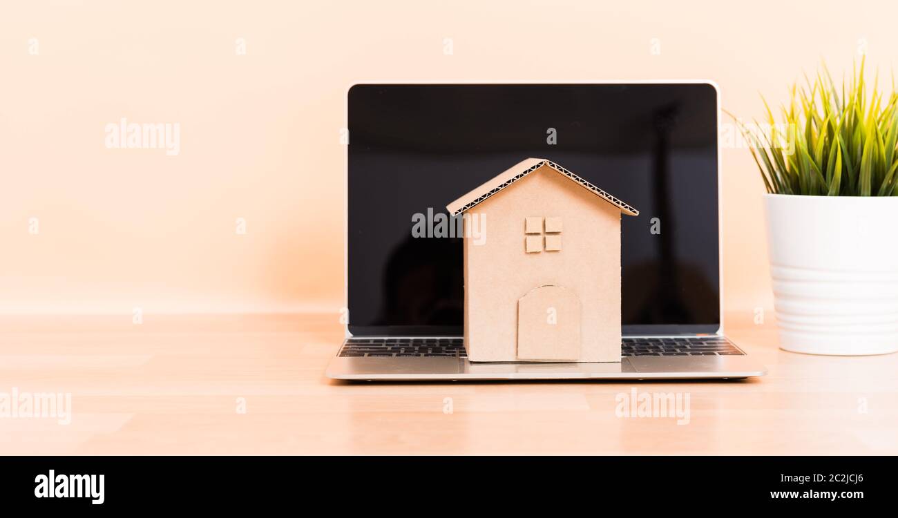 Pappe Papier Modell Haus und Computer Laptop, immobilie Hypothek mieten kaufen Konzept Stockfoto