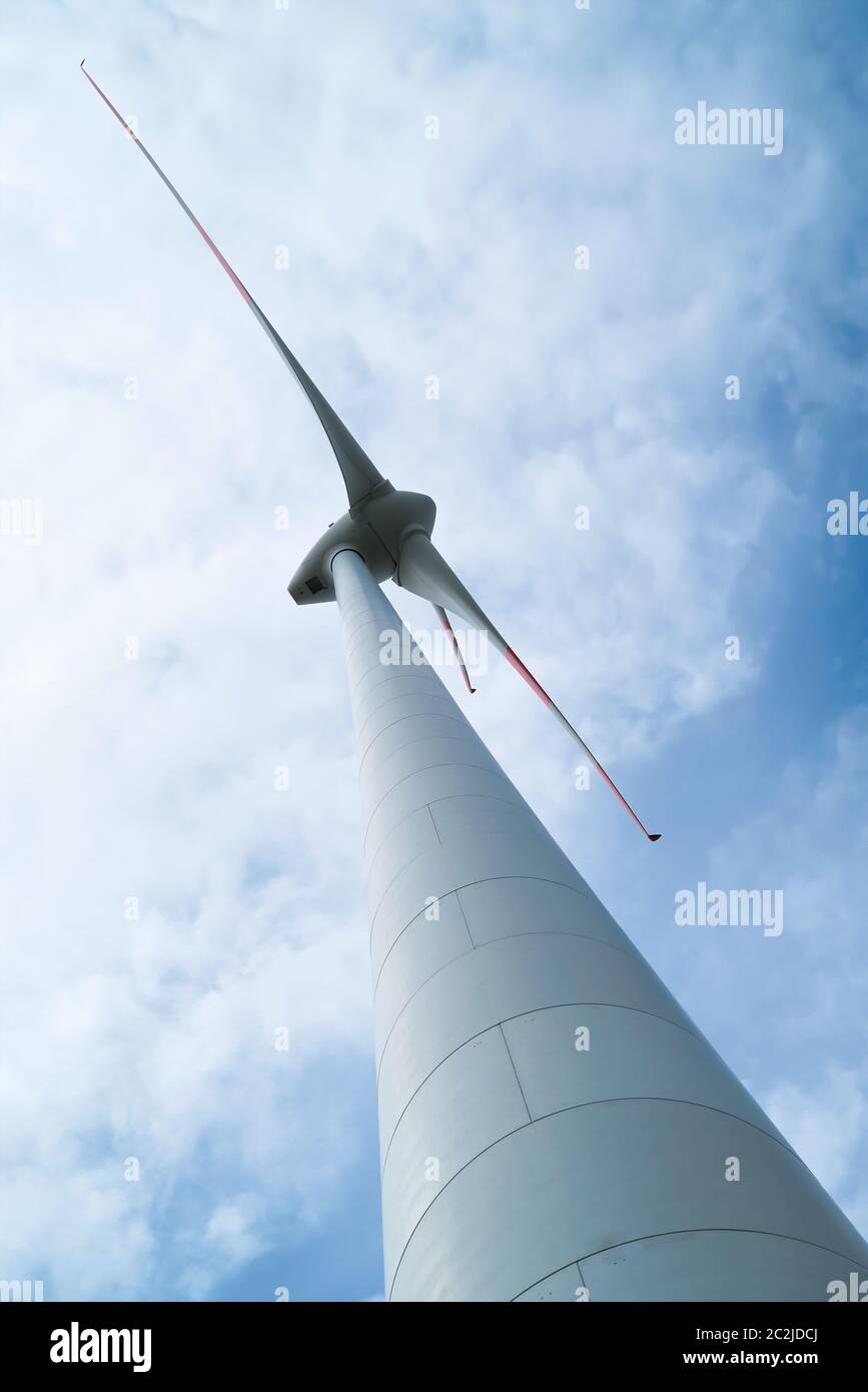 Blick von unten auf die Rotorblätter einer Windenergieanlage Stockfoto