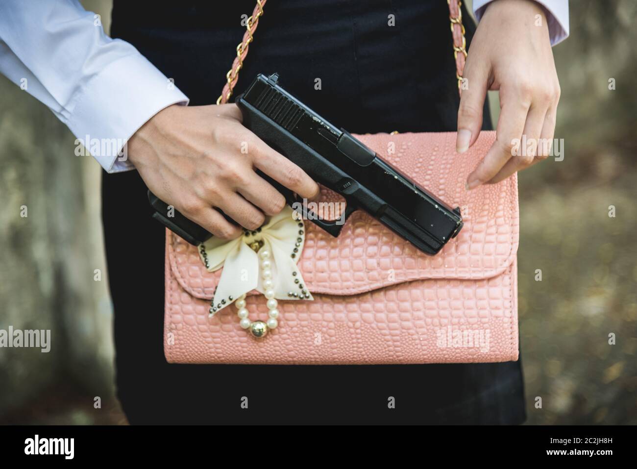 Junge Frau mit verborgenen Waffe Waffe in der kleine Handtasche Stockfoto