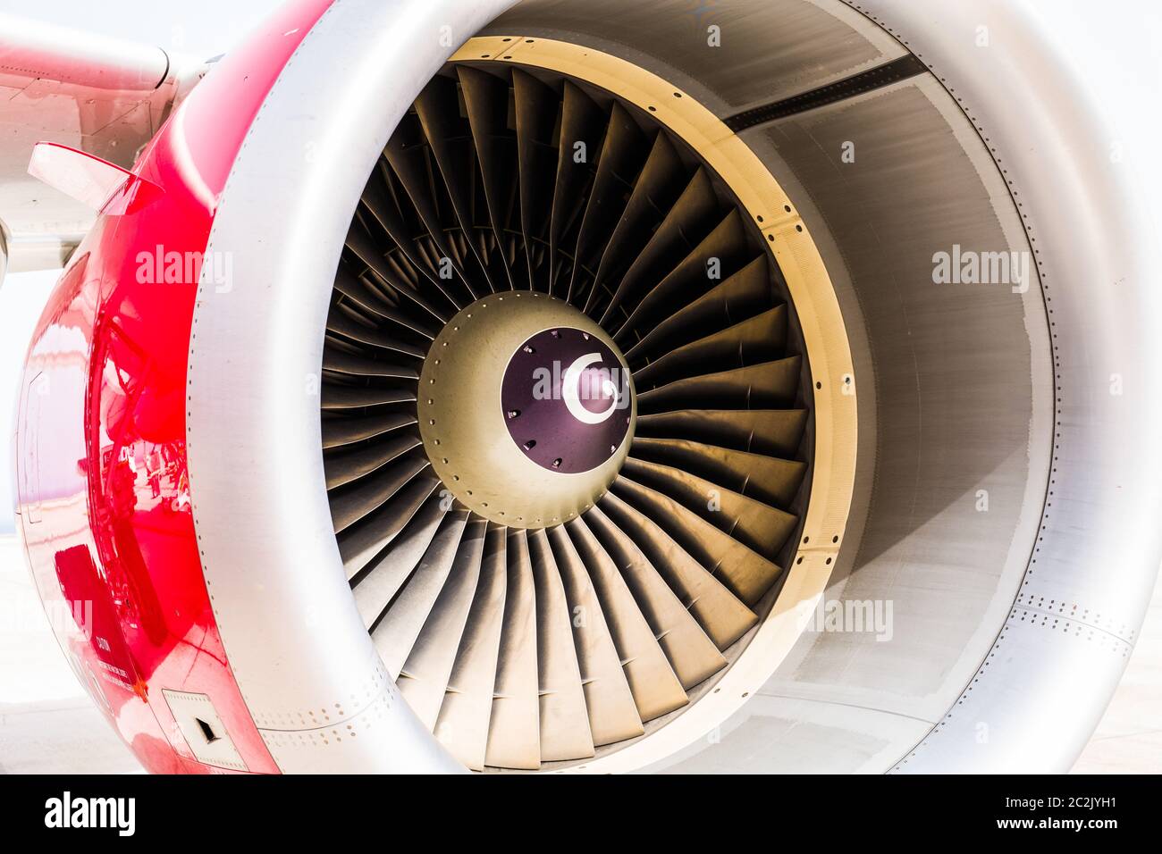 Detailreiche Nahaufnahme des Triebwerks eines Düsenflugzeugs mit roter Verkleidung und weißem Hintergrund Stockfoto
