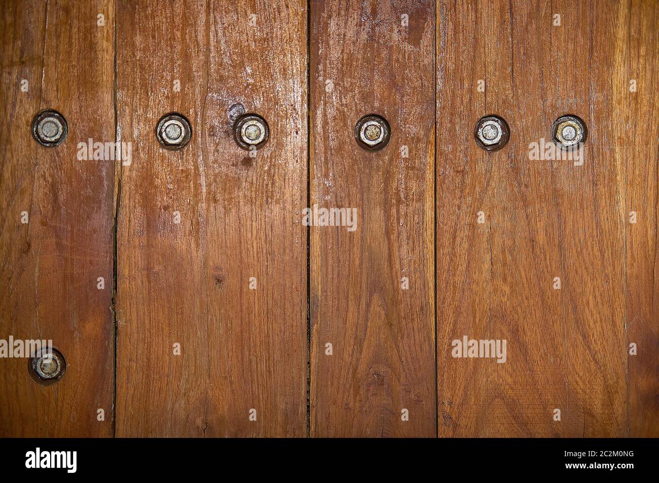 Die Beschaffenheit der dunklen Holzplanken mit sichtbaren Schrauben. Stockfoto