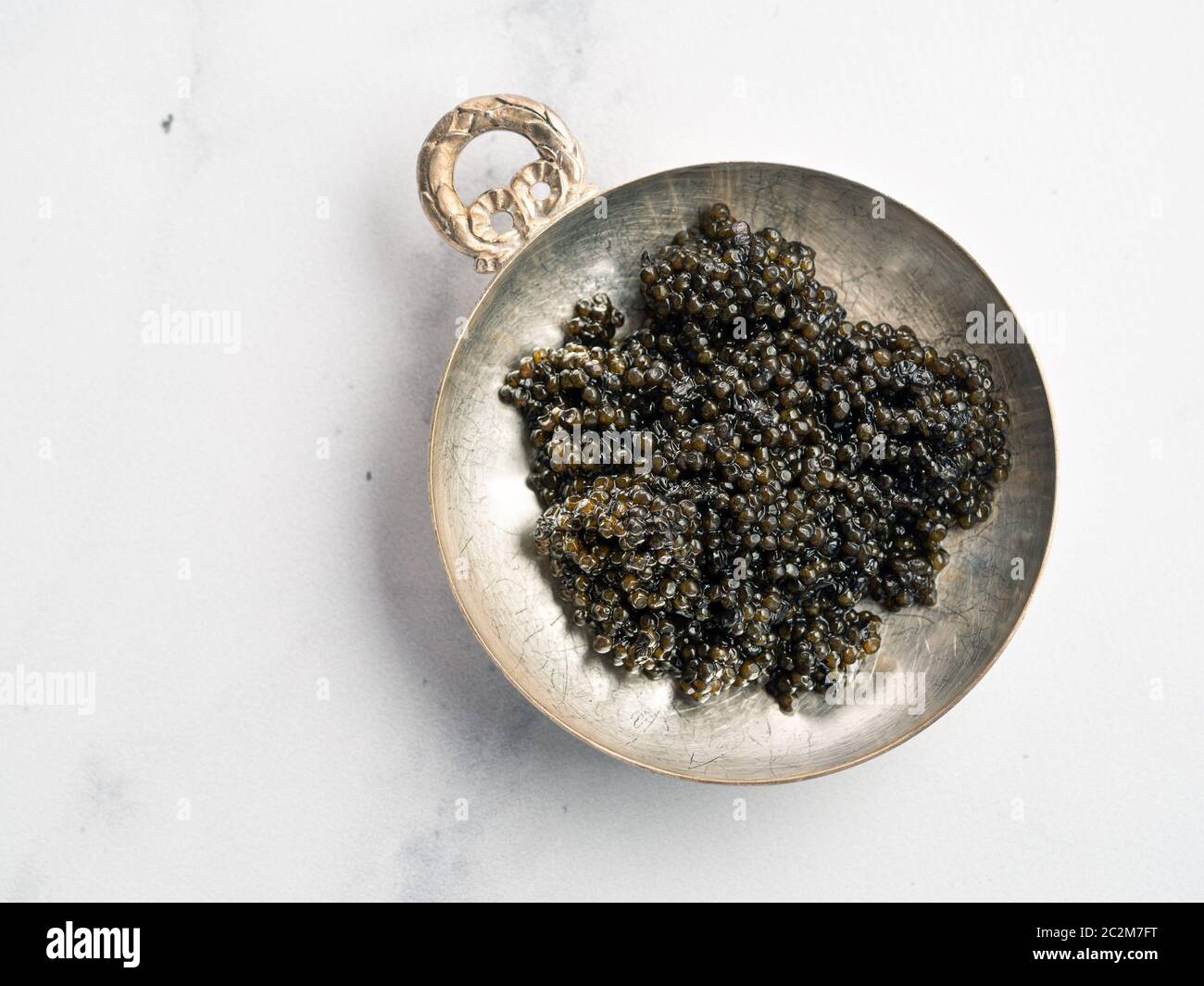 Schale mit schwarzem Kaviar auf weißem Marmor Stockfoto