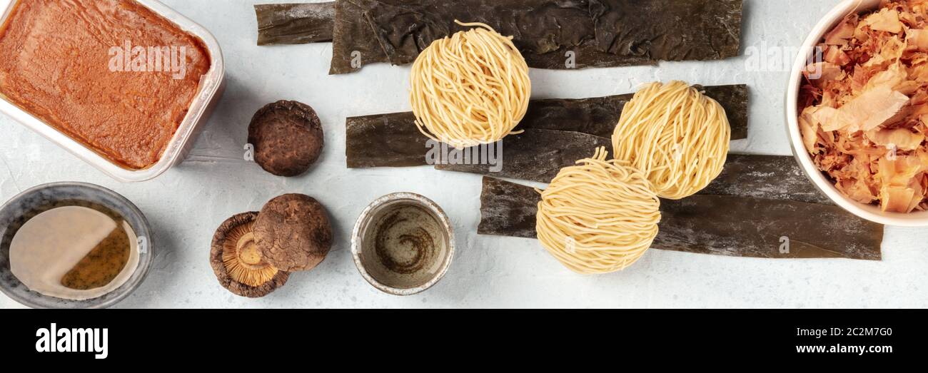 Ramen Zutaten Panorama. Getrockneter Seegrüsenkelch, Soba, Miso-Paste, Bonito-Flocken, Shiitake-Pilze, Sake, Mirin, Overhead Stockfoto