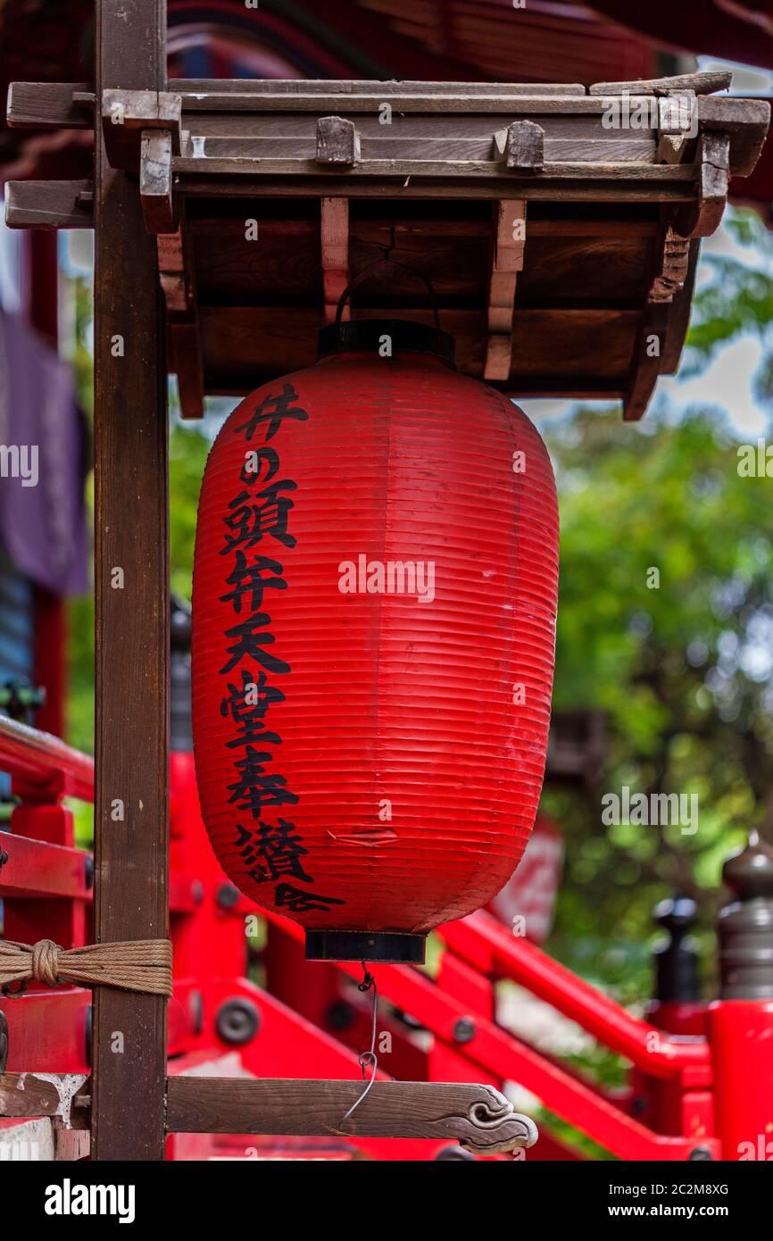 Traditionelle japanische rote Papierlaterne mit Hieroglyphen, am Eingang des Tempels. Stockfoto