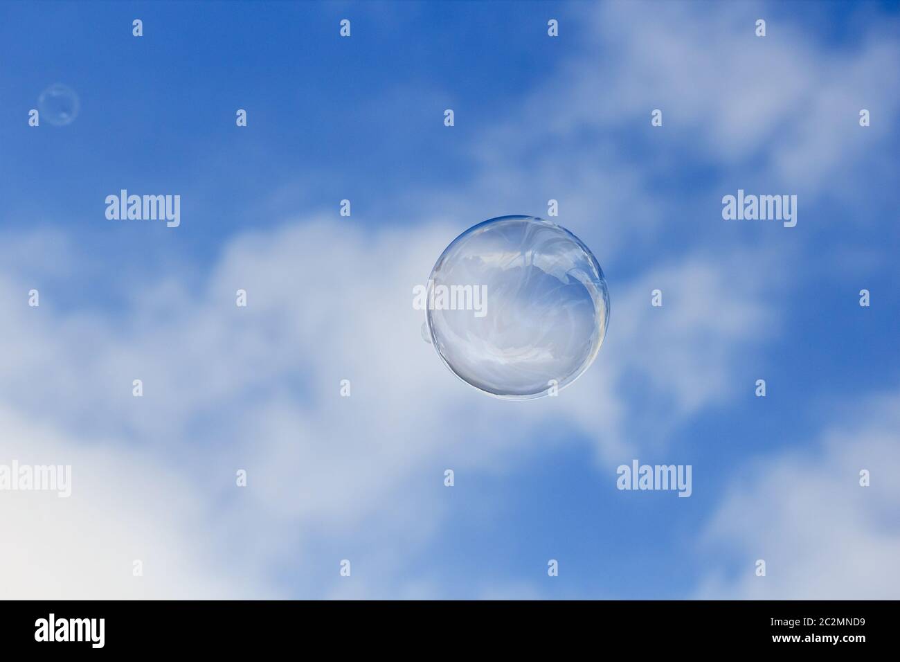 Eine Seifenblase schwimmt in der Luft isoliert auf wolkig blauen Himmel Stockfoto