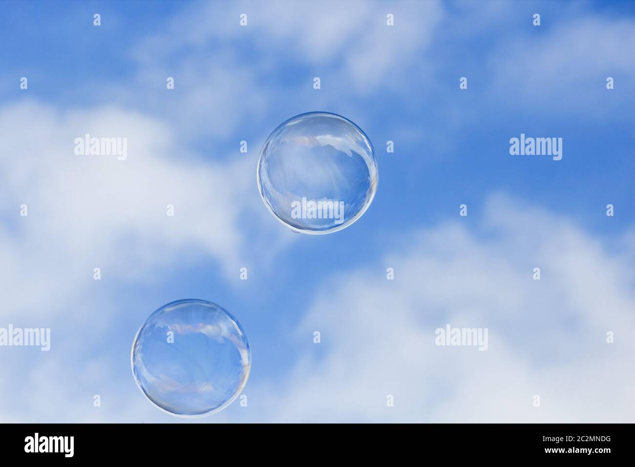 Zwei schwimmende Seifenblasen gegen blauen Himmel mit Kopierraum Stockfoto