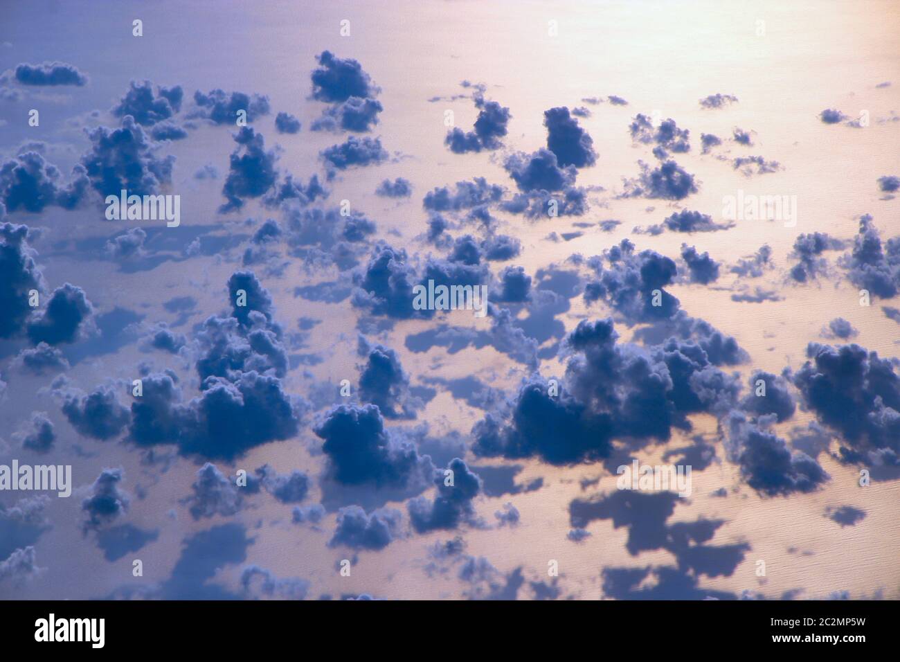 Schöne Aussicht vom Fenster des Flugzeugs über Wolken und Meeresoberfläche fliegen Stockfoto