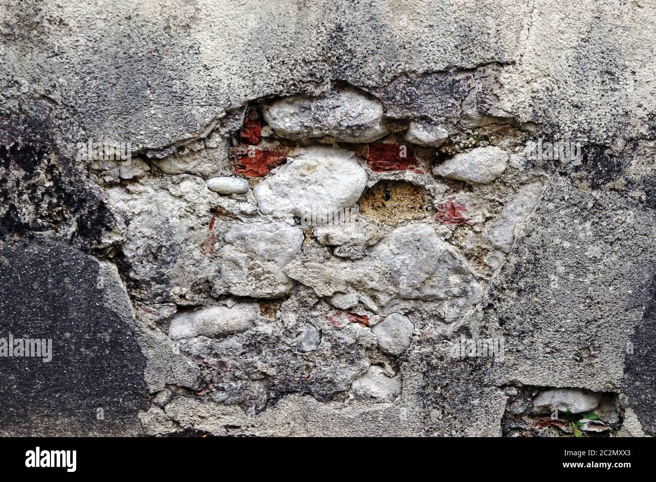 Eine kaputte, verfallene Steinmauer. Eine beschädigte Hauswand Stockfoto