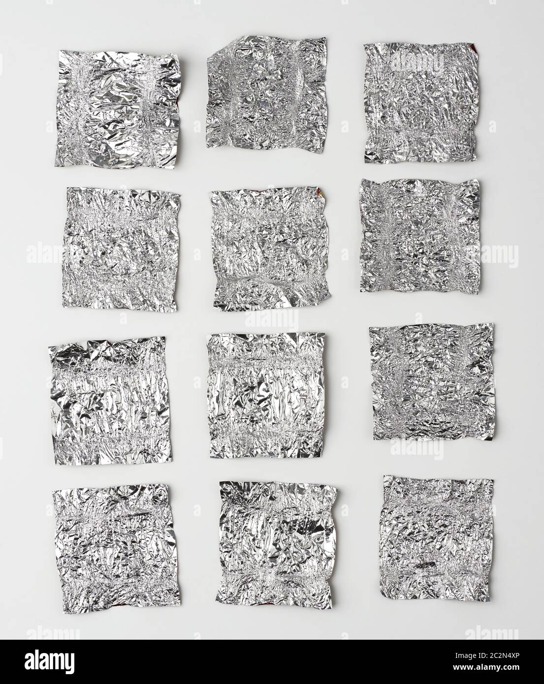Verschiedene zerknitterte Folien verwendeten Süßigkeiten-Wrapper auf weißem Hintergrund, Draufsicht Stockfoto