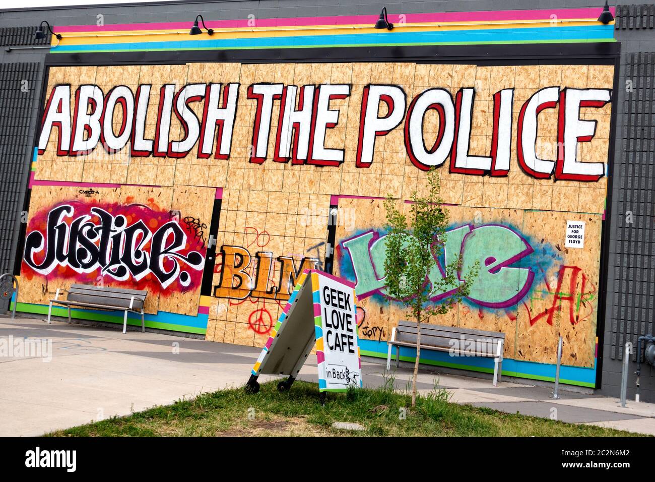 Große Grafik „Abschaffen der Polizei“ zusammen mit „Justice BLM Love“ auf Sperrholz nach George Floyd Tod auf Greek Love Cafe. Minneapolis Minnesota, USA Stockfoto