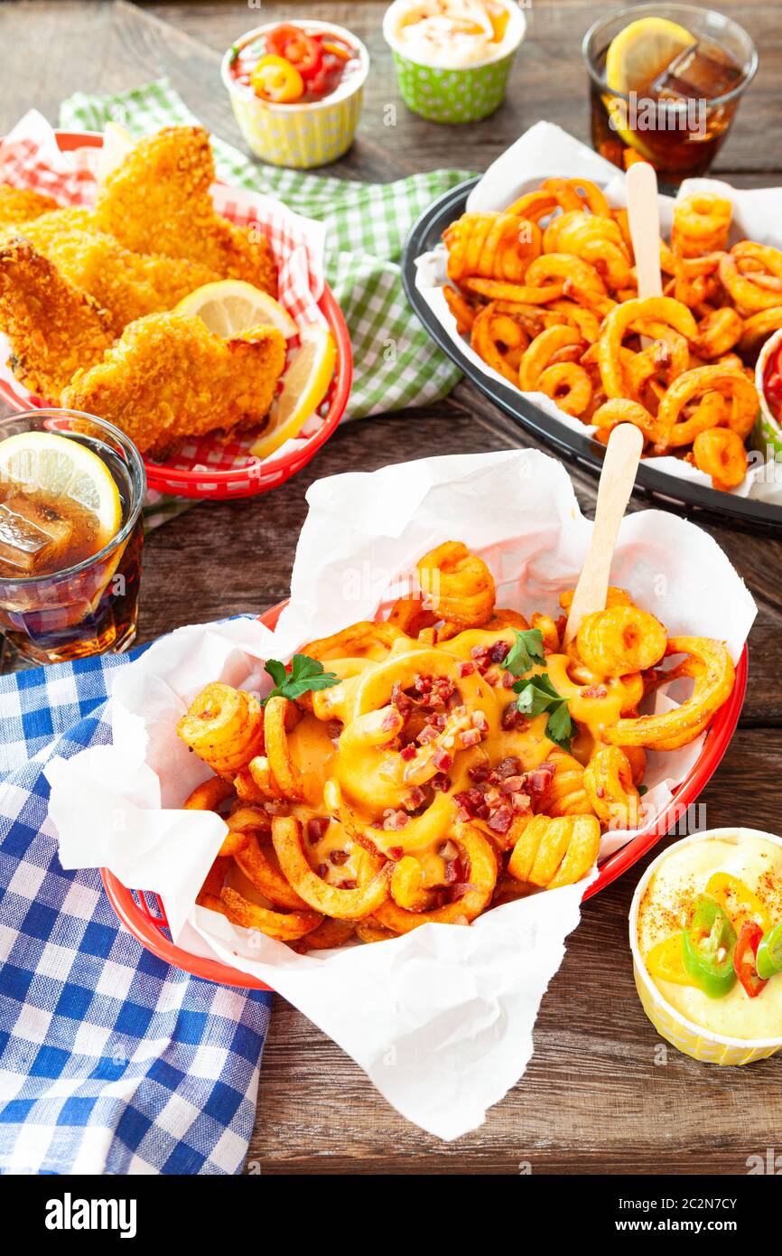Leckere fast Food mit lockigen Pommes Frites und gebratenen Hähnchenfingern Stockfoto